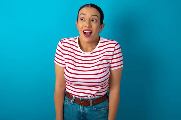 Surprised Woman Wearing Striped Shirt Shrugs Shoulders Looking Sideways Being — Stock Photo, Image
