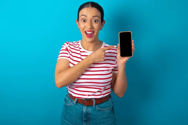 Vzrušená Žena Pruhovaném Tričku Která Drží Ukazuje Prstem Smartphone Prázdnou — Stock fotografie