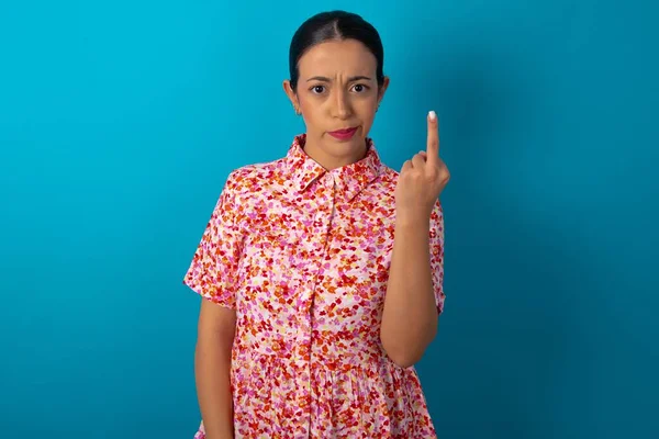 フローラルドレスを着ている女性は 中指の悪い兆候が気にしないように求めていることを示しています 提供と失礼な態度 — ストック写真