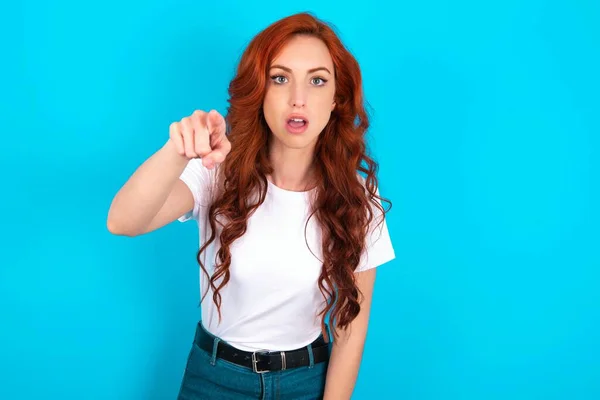 Shocked Redhead Woman Wearing White Shirt Blue Background Points Front — Stock Photo, Image