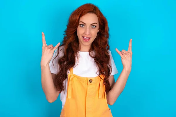 Redhead Woman Wearing Orange Overall Blue Background Makes Rock Roll — Stock Photo, Image