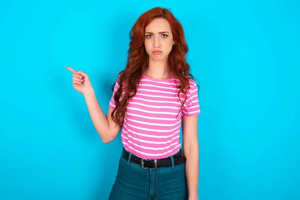 Serious Redhead Woman Wearing Pink Striped Shirt Blue Background Smirks — Stock Photo, Image