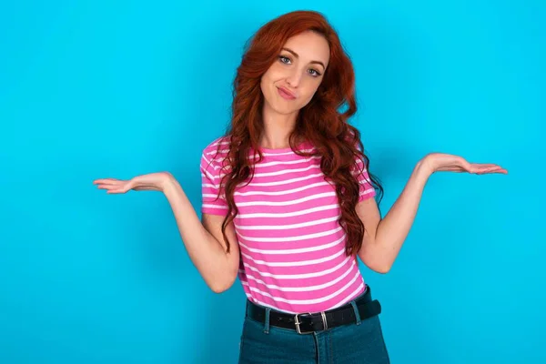 Descuidado Atractivo Pelirroja Mujer Usando Rosa Rayas Camiseta Sobre Azul —  Fotos de Stock