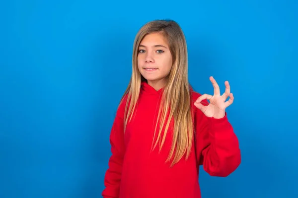 Schöne Kaukasische Teenie Mädchen Trägt Rotes Sweatshirt Über Blauem Hintergrund — Stockfoto