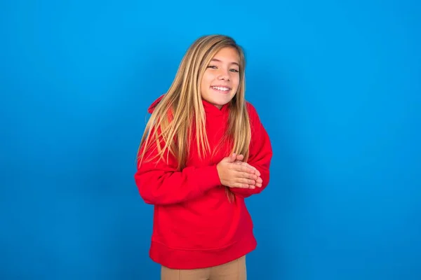 青い背景の上に赤いスウェットシャツを着ているコーカサスティーンガールは 幸せを感じ 笑顔と拍手を言って 拍手で祝福 — ストック写真