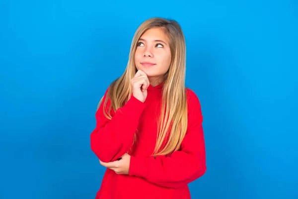 Portret Van Bedachtzame Blanke Tienermeisje Draagt Rode Sweater Blauwe Achtergrond — Stockfoto