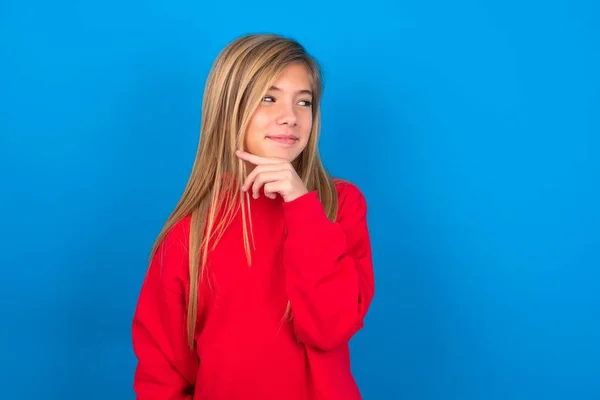 Dromerige Blanke Tiener Meisje Draagt Rode Sweater Blauwe Achtergrond Met — Stockfoto