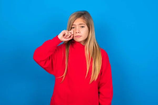 Unhappy Caucasian Teen Girl Wearing Red Sweatshirt Blue Background Crying — Stock Photo, Image