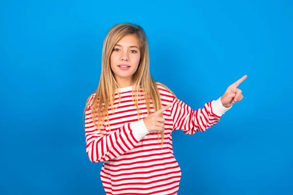 Blondynka Nastolatka Dziewczyna Paski Shirt Niebieskiej Ścianie Pozytywnym Wyrazem Wskazuje — Zdjęcie stockowe