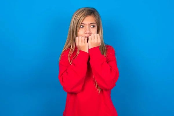 Zaniepokojona Biała Nastolatka Czerwonej Bluzie Niebieskim Tle Zakrywająca Usta Dłońmi — Zdjęcie stockowe