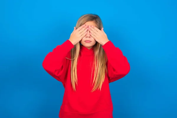 Blond Blank Tienermeisje Draagt Rood Sweatshirt Blauwe Achtergrond Die Ogen — Stockfoto