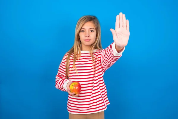 Nastolatka Dziewczyna Pasiastej Koszuli Niebieskim Tle Robi Gest Stop Dłoni — Zdjęcie stockowe