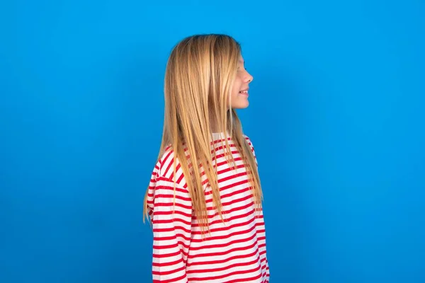 Профиль Улыбающейся Девушки Подростка Полосатой Рубашке Синем Фоне Здоровой Кожей — стоковое фото