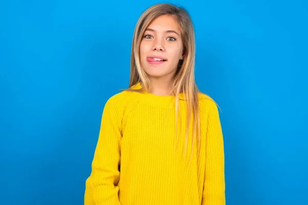 Divertido Caucásico Adolescente Chica Usando Amarillo Suéter Sobre Azul Estudio —  Fotos de Stock
