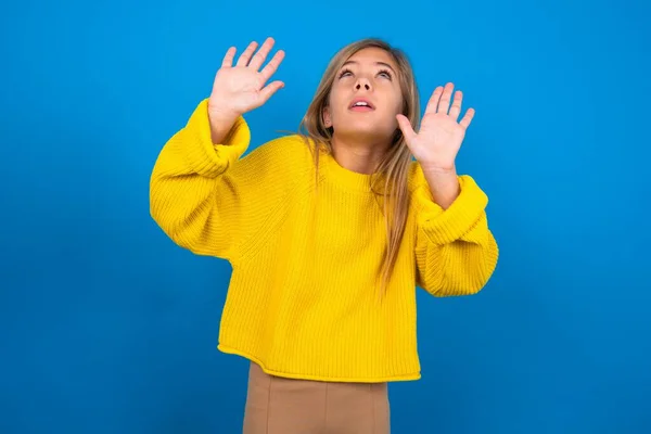 Kaukasisches Teenie Mädchen Gelbem Pullover Über Blauem Studiohintergrund Hält Handflächen — Stockfoto