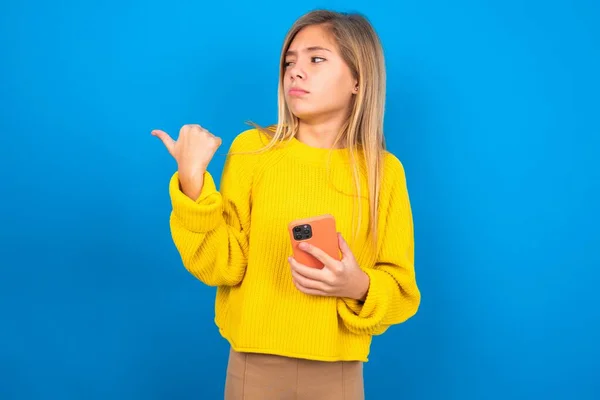 Hermosa Caucásico Adolescente Chica Usando Amarillo Suéter Sobre Azul Estudio — Foto de Stock