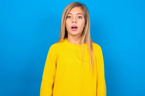 ブルースタジオのバックグラウンドスターに黄色のセーターを着用したショックを受けたセルカシアの十代の少女は 口を開いたままの目は 驚くべき表情をしています Omgコンセプト — ストック写真