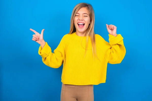 Fröhliche Kaukasische Teenie Mädchen Tragen Gelben Pullover Über Blauem Studiohintergrund — Stockfoto