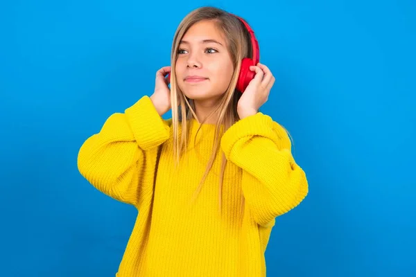 Chica Adolescente Caucásica Con Suéter Amarillo Sobre Fondo Azul Estudio —  Fotos de Stock
