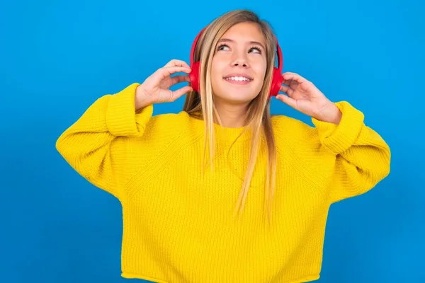 Alegre Caucásico Adolescente Chica Usando Amarillo Suéter Sobre Azul Estudio —  Fotos de Stock
