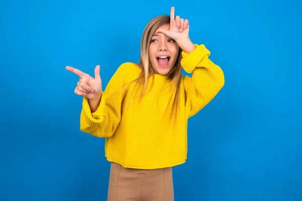 Kaukasisches Teenie Mädchen Gelbem Pullover Über Blauem Studiohintergrund Zeigt Verlierer — Stockfoto