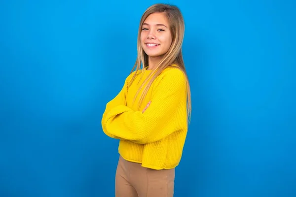 Portret Białej Nastolatki Noszącej Żółty Sweter Niebieskim Tle Studia Stojącej — Zdjęcie stockowe