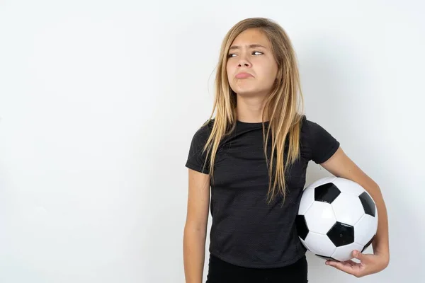 Dissatisfied Teen Girl Wearing Sportswear Holding Football Ball White Wall — Stock Photo, Image