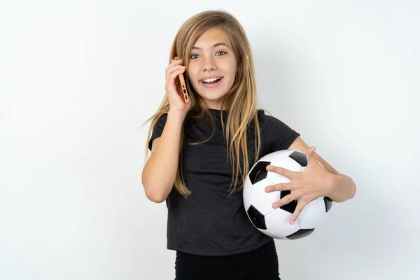 Glimlachend Tienermeisje Draagt Sportkleding Met Een Voetbalbal Witte Muur Praat — Stockfoto