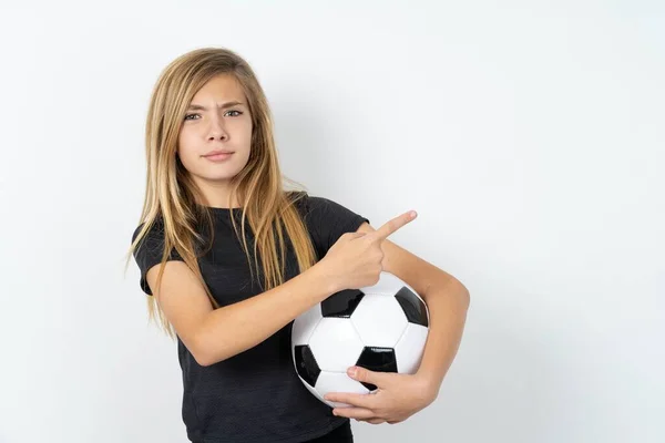 Seriös Tonåring Flicka Bär Sportkläder Håller Fotboll Över Vit Vägg — Stockfoto