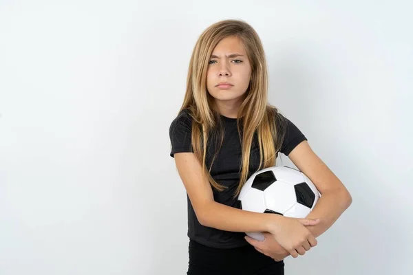 Teenagermädchen Sportbekleidung Hält Fußballball Über Weiße Wand Zeigt Mit Fingern — Stockfoto