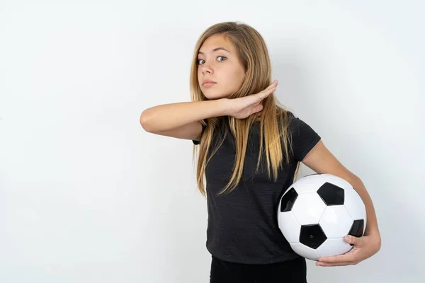 身穿运动服的少女拿着足球冲过白墙 手拿着刀割喉 凶狠地扬言要进攻 — 图库照片