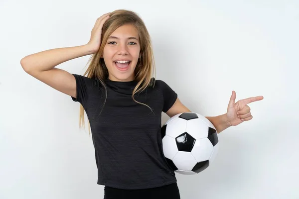 身穿运动服 拿着足球冲过白墙 手挽手冲向空旷场地的少女感到惊讶 — 图库照片