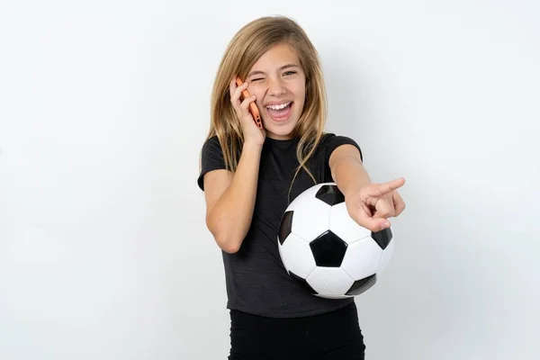 Pozytywne Nastolatka Odzieży Sportowej Trzyma Piłkę Nożną Nad Białą Ścianą — Zdjęcie stockowe