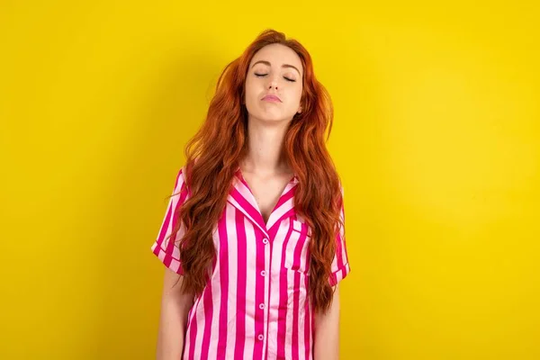 Jonge Roodharige Vrouw Draagt Roze Pyjama Gele Studio Achtergrond Zoek — Stockfoto