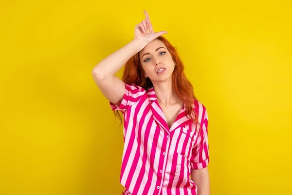 Joven Mujer Pelirroja Usando Pijama Rosa Sobre Fondo Estudio Amarillo — Foto de Stock