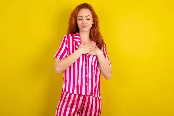 Joven Mujer Pelirroja Vistiendo Pijama Rosa Sobre Fondo Amarillo Estudio — Foto de Stock