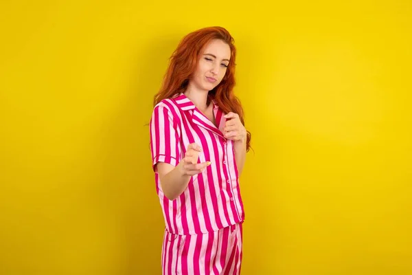 Joven Mujer Pelirroja Con Pijama Rosa Sobre Fondo Estudio Amarillo — Foto de Stock