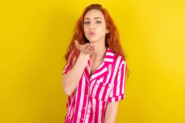 Sarı Arka Planda Pembe Pijama Giyen Kızıl Saçlı Kadın Kameraya — Stok fotoğraf