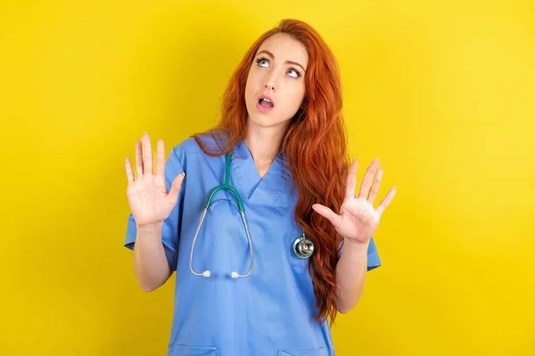 Young Red Haired Doctor Woman Yellow Studio Background Keeps Palms — Stock Photo, Image