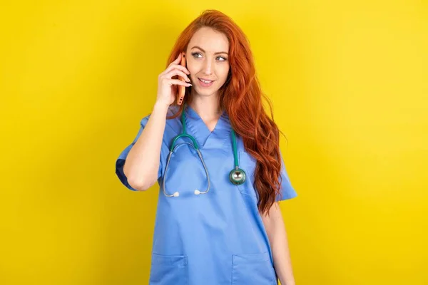 Trevligt Ser Glad Ung Rödhårig Läkare Kvinna Över Gul Studio — Stockfoto