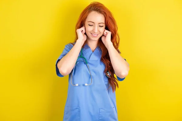Joven Médico Pelirrojo Mujer Sobre Amarillo Estudio Sonríe Alegremente Imagina —  Fotos de Stock