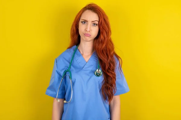 Displeased Young Red Haired Doctor Woman Yellow Studio Background Frowns — Stock Photo, Image