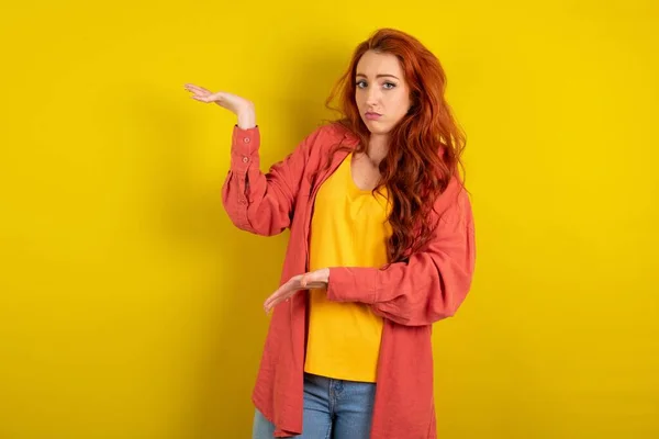 Beautiful Red Haired Woman Standing Yellow Studio Background Pointing Aside — Stock Photo, Image