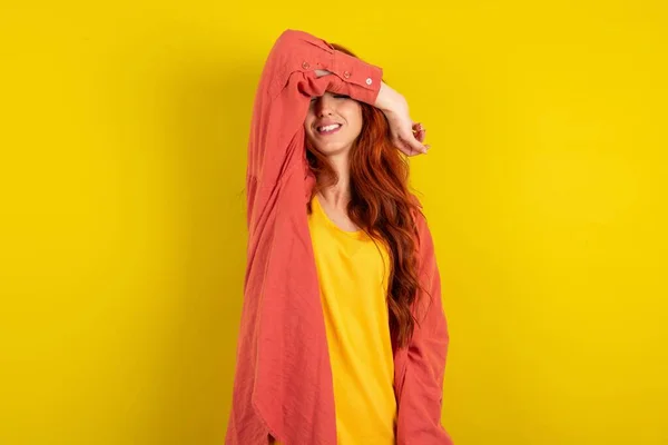 Hermosa Mujer Pelo Rojo Pie Sobre Fondo Amarillo Estudio Cubriendo —  Fotos de Stock