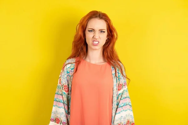 Red Haired Woman Yellow Studio Background Keeps Teeth Clenched Frowns — Stock Photo, Image