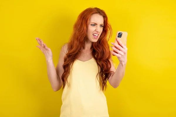 Sarı Arka Planda Sarı Tişört Giyen Kızgın Kızıl Saçlı Kadın — Stok fotoğraf