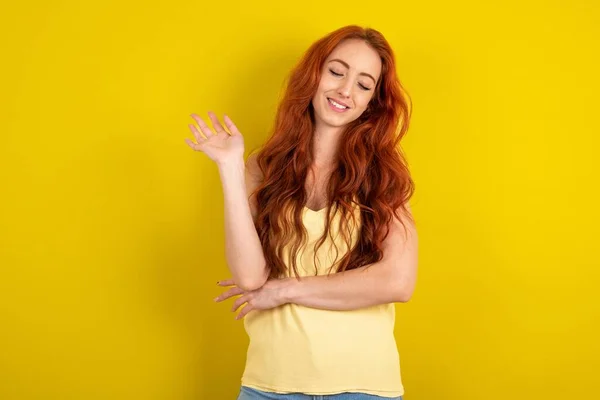 黄色いスタジオの背景に黄色いシャツを着た美しい美しい赤毛の女性は 友人によって楽しませられる喜びで目を閉じます — ストック写真