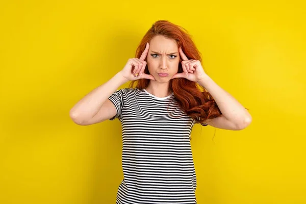 Serious Concentrated Red Haired Woman Wearing Striped Shirt Yellow Studio — Stock Photo, Image