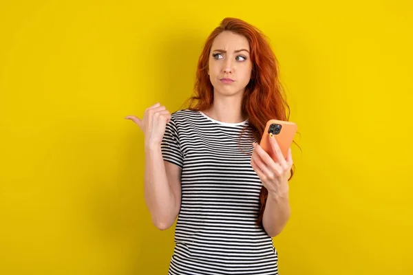 Red Haired Woman Wearing Striped Shirt Yellow Studio Background Points — Stock Photo, Image