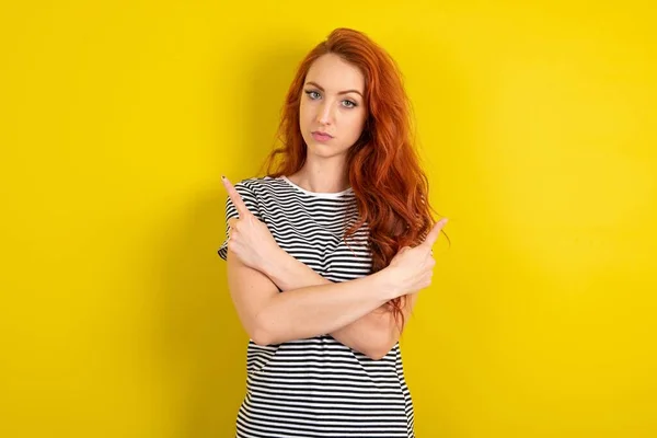 Ernstige Roodharige Vrouw Draagt Gestreept Shirt Gele Studio Achtergrond Kruist — Stockfoto